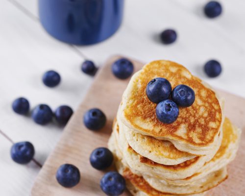 Pancakes with blueberry on cutting board